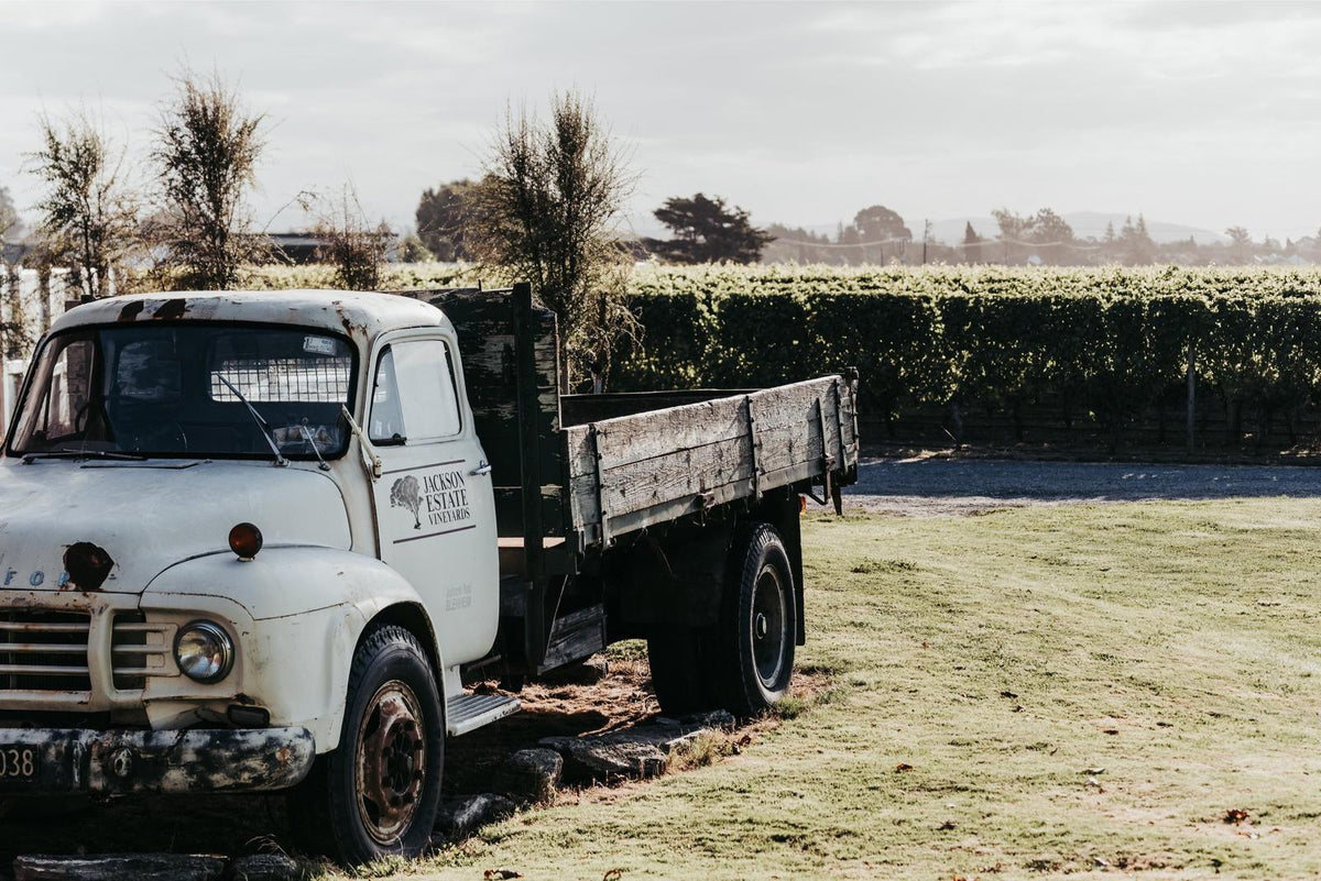 A vintage Jackson Estate Vineyards farm truck parked beside the Marlborough vines