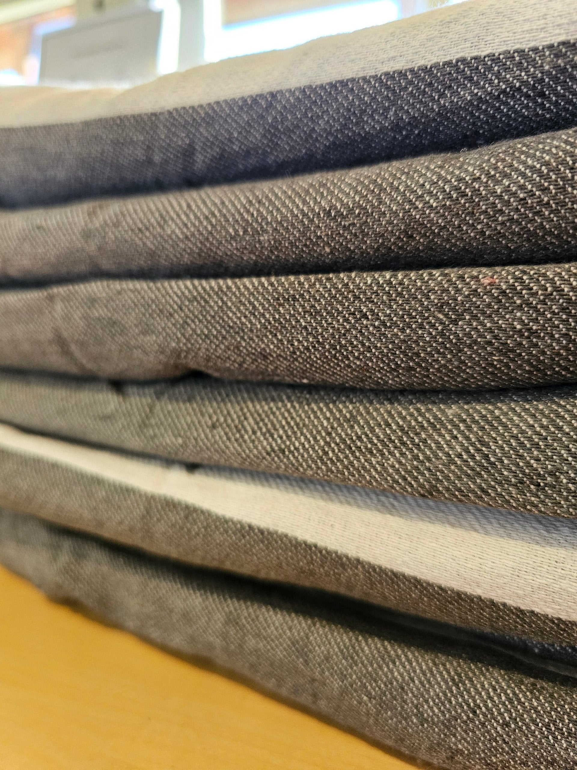 Stack of folded dark fabric menus or folders on a wooden surface