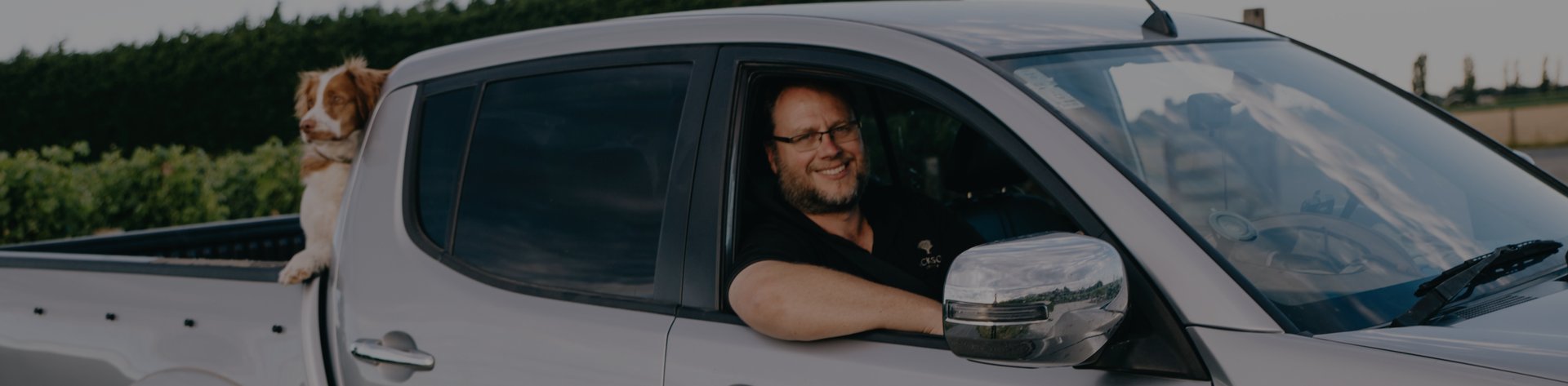 Jackson Estate winemaker Matt Patterson-Green leaning out of a silver pickup truck window, dog visible in the truck bed